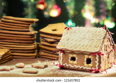 Decorating gingerbread cottage on Christmas tree background