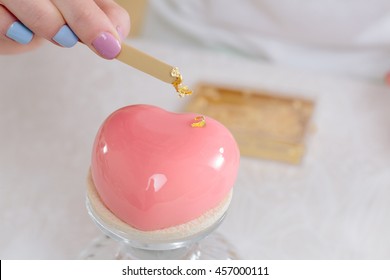 Decorating A Heart Cake With Gold Leaf