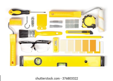 Decorating And House Renovation Tools And Accessories On White Background Top View. Flat Lay Composition In Yellow Colors