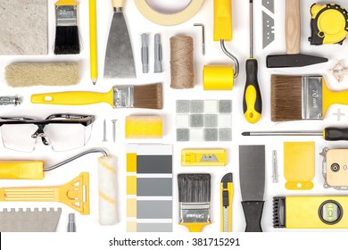 Decorating And House Renovation Tools And Other Essentials On White Background Top View. Flat Lay Composition In Yellow Colors