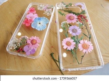 Decorating Phone Case With Dry Flower Following Diy Ideas On Wooden Table. 