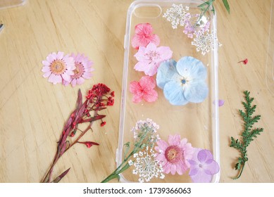 Decorating Phone Case With Dry Flower Following Diy Ideas On Wooden Table. Creative DIY Project.