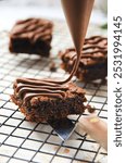 decorating sliced brownies with melted chocolate using piping bag