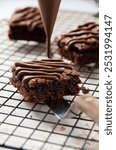 decorating sliced brownies with melted chocolate using piping bag