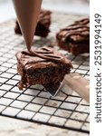 decorating sliced brownies with melted chocolate using piping bag