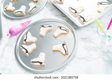 Decorating Sugar Cookies Shaped As Figure Skates With Royal Icing.