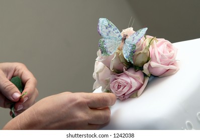 Decorating White Wedding Cake With Roses And Butterfly.