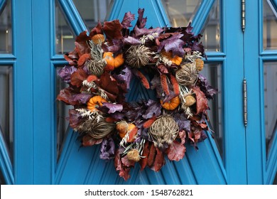 Decoration Of Building Facade (door) With Decorative Pumpkins For Halloween Holiday In Moscow City, Russia. Beautiful Autumn Decor - Wreath - With Fall Plants, Dried Flowers, Leaves, Orange Pumpkins