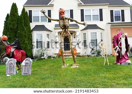 Decoration of the facade of the house for the holiday of Halloween. Pumpkin skeletons and terrible monsters on the lawn.