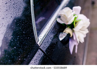 Decoration Of Flowers Roses On The Door Handle Of The Car Covered With Drops Of Rain On Your Wedding Day