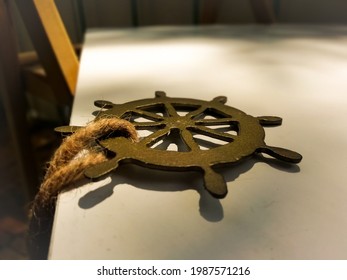 Decoration In The Form Of A Ship's Rudder And Rope On A White Background.