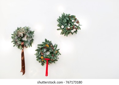 decoration, handmade, holidays concept. three wonderful christmas wreathes with silk ribbons, with pinecones and dried fruits, with red berries and small white flowers of cotton - Shutterstock ID 767173180