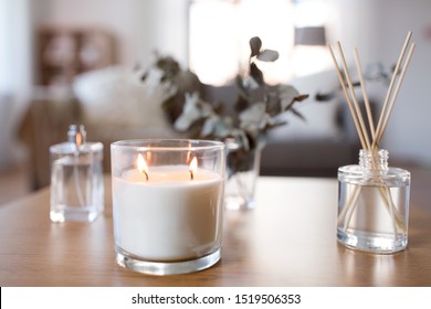 Decoration, Hygge And Aromatherapy Concept - Aroma Reed Diffuser, Burning Candle And Perfume On Table At Home