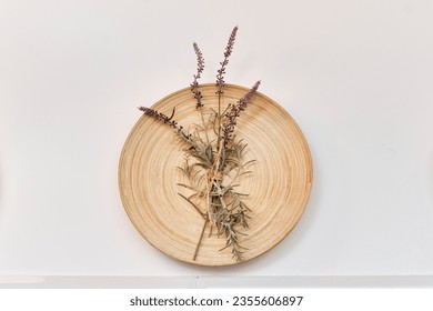 Decoration for interior of living room, dining room, kitchen.Wall-mounted wooden round panel with small bouquet of dry sprigs of lavender, rosemary on white wall. - Powered by Shutterstock