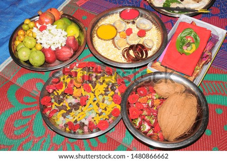 Decoration of plates at function. its tradition in indian hindu family to celebrate with fruits drynuts coconut flowers some new cloths fruits etc