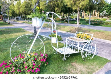 Decoration tricycle in public garden background. Decorative white metal pedicap with flowerpot in park  - Powered by Shutterstock
