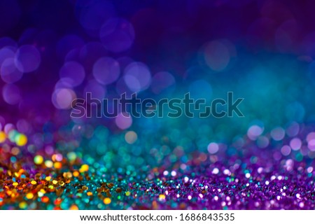 Decoration twinkle lights background, abstract blurred backdrop with circles,modern design overlay with sparkling glimmers. Blue, purple, golden and green backdrop glittering sparks with glow effect
