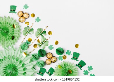 Decorations and props for St.Patrick 's Day party. Green and gold paper decorations, hat, balloons, confetti, candy and lucky symbols on white background. Festive concept. Flat lay, top view. - Powered by Shutterstock