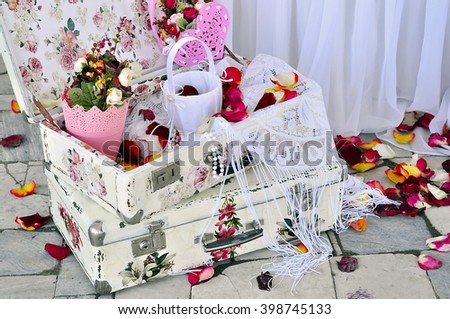 Decorations for the wedding ceremony. Old decoupage suitcases , flowers, rose petals and other accessories.