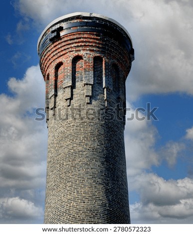 Decorative and aging brickwork can be seen on this hisoric smokesack, in Columbia, South Carolina.  Steel bands can be seen securing top of stack.  It is located on the campus of University of South Carolina.