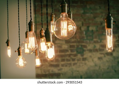 Decorative antique edison style filament light bulbs against brick wall
