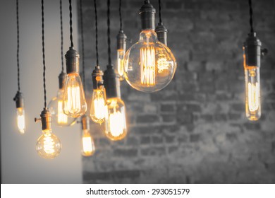 Decorative antique edison style filament light bulbs against brick wall - Shutterstock ID 293051579