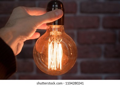 Decorative antique edison style light tungsten bulbs against brick wall background. Close-up. - Shutterstock ID 1104280241