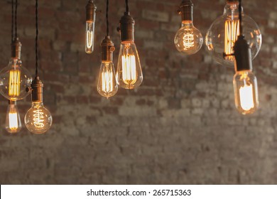 Decorative antique edison style light bulbs against brick wall background