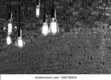 Decorative antique edison style light bulbs against brick wall background - Shutterstock ID 346738424