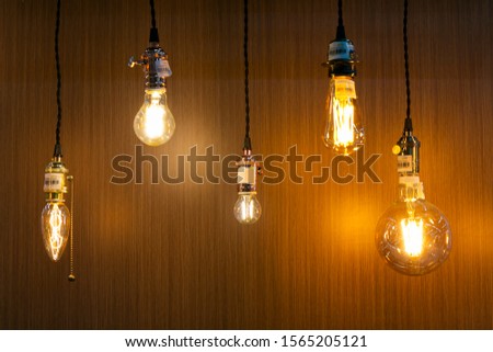 Decorative antique edison style light bulbs on wooden wall background.