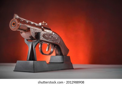 Decorative Antique Musket Pistol On A Stand Against The Gradient Orange Background.