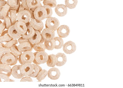 Decorative border of beige rings corn flakes isolated with copy space. Cereals background.