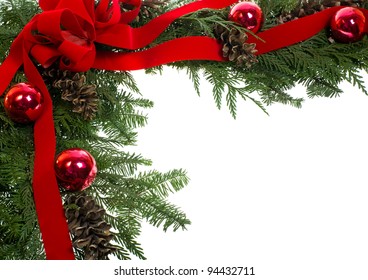 A Decorative Border Of Pine Boughs Ornaments Cones Ribbon And Bow Isolated On White