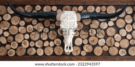 Decorative carved skull of longhorn bull on the wall with wooden background