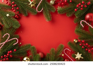 A decorative Christmas border featuring fir branches, candy canes, and ornaments on a vibrant red background, creating a festive and cheerful holiday atmosphere - Powered by Shutterstock