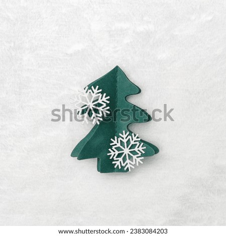 Decorative Christmas tree from green craft paper, Christmas and New Year holiday composition. Handmade green fir decorated snowflakes on white fur background. Top view, flat lay, Winter holidays card