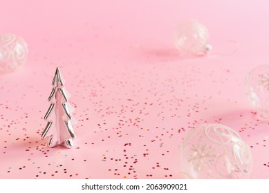 Decorative Christmas tree and transparent balls on pink background with colorful star shaped confetti. Minimal Christmas background
