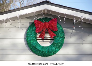 A Decorative Christmas Wrath Displayed On The Front Of A House