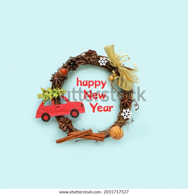 decorative\
christmas wreath and retro toy car on blue background. Happy New\
Year. festive winter season concept. flat\
lay
