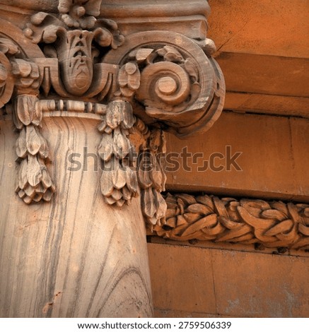 Decorative column has broken scrollwork.  Wooden carving has flowers aand spirals.
