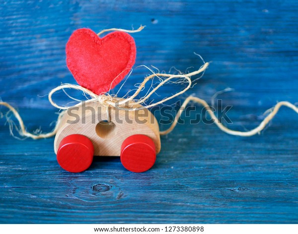  Decorative\
composition of a toy car and a heart made of felt on a blue\
background, the concept of congratulations on Valentine\'s Day,\
holiday decorations, greeting\
card\
