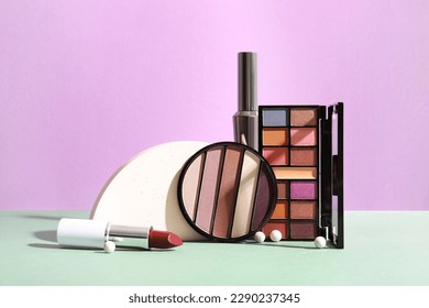 Decorative cosmetics with podium on table near lilac wall