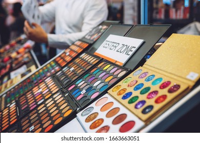 Decorative Cosmetics Tester Zone, Samples, Testers. Various Eye Liners, Brow Sticks In Showcase Of Beauty Shop. Stand With Bright Colored Tester Eye Shadow Samples In Beauty Store.