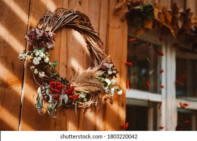 Decorative design window on the terrace. autumn wreath and pumpkins vintage old chest of drawers on wooden rustic background. autumn composition and recreation area sun ray