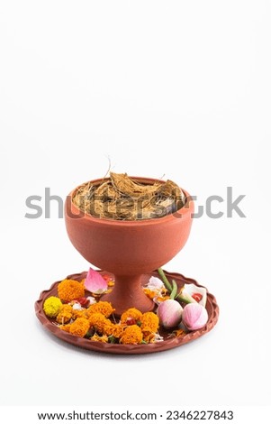 DECORATIVE DHUNUCHI WITH CLAY THALI,MARIGOLD FLOWER, AND LOTUS ISOLTED ON WHITE BACKGROUND WITH SELECTIVE FOCUS.