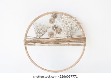 decorative dry flowers. boho wreath with dry flowers. Wooden hoop, thread and dry herbs wreath hanging on wall. Modern floral arrangement and creative handmade decor. High quality photo - Powered by Shutterstock