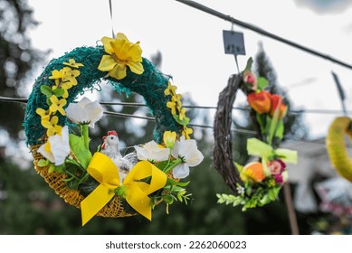 decorative Easter wreath with a yellow bow and golden rain in which a white hen sits as a symbol of spring and Easter. the wreath is sold at the Easter fair
 - Shutterstock ID 2262060023