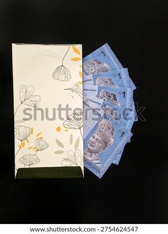 Decorative envelope with Malaysian Ringgit notes, symbolizing festive money-giving tradition during Hari Raya or Eid Mubarak. 