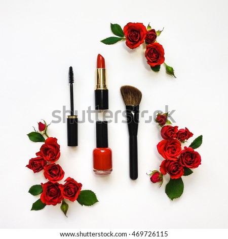 Decorative flat lay composition with woman cosmetics and red rose flowers. Flat lay, top view on white background, make up
