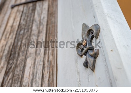A decorative fleur de lis shaped doorbell in the French Quarter in New Orleans.